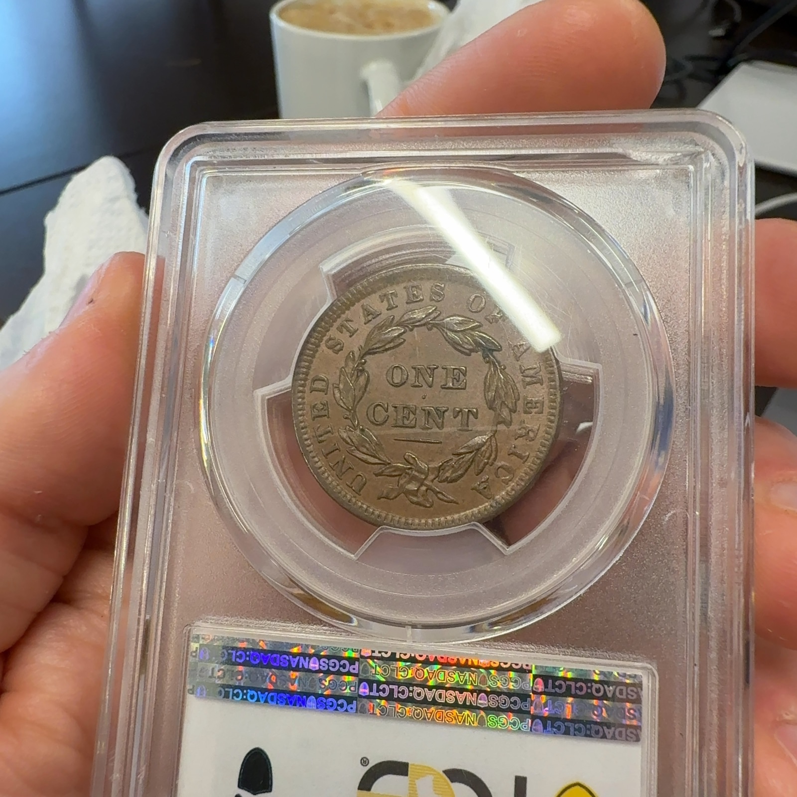 Handheld phone photograph 8 of the 1838 Coronet Large Cent in its holder