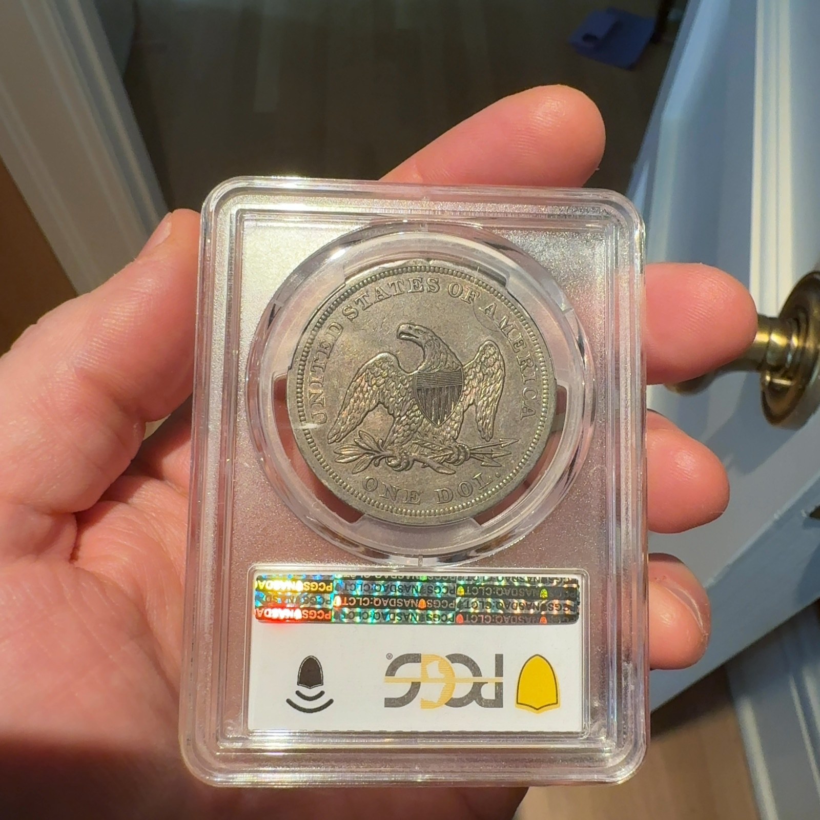Handheld phone photograph 6 of the 1842 Silver Dollar in its holder