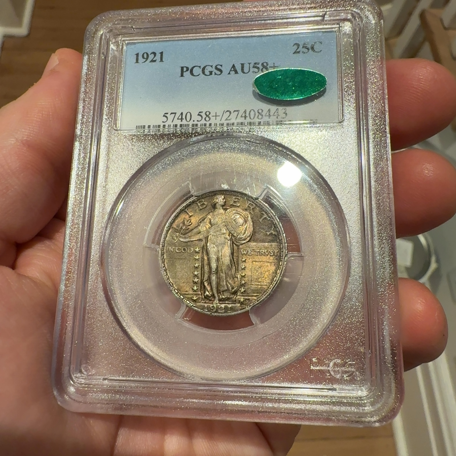 Handheld phone photograph 4 of the 1921 Standing Liberty Quarter in its holder