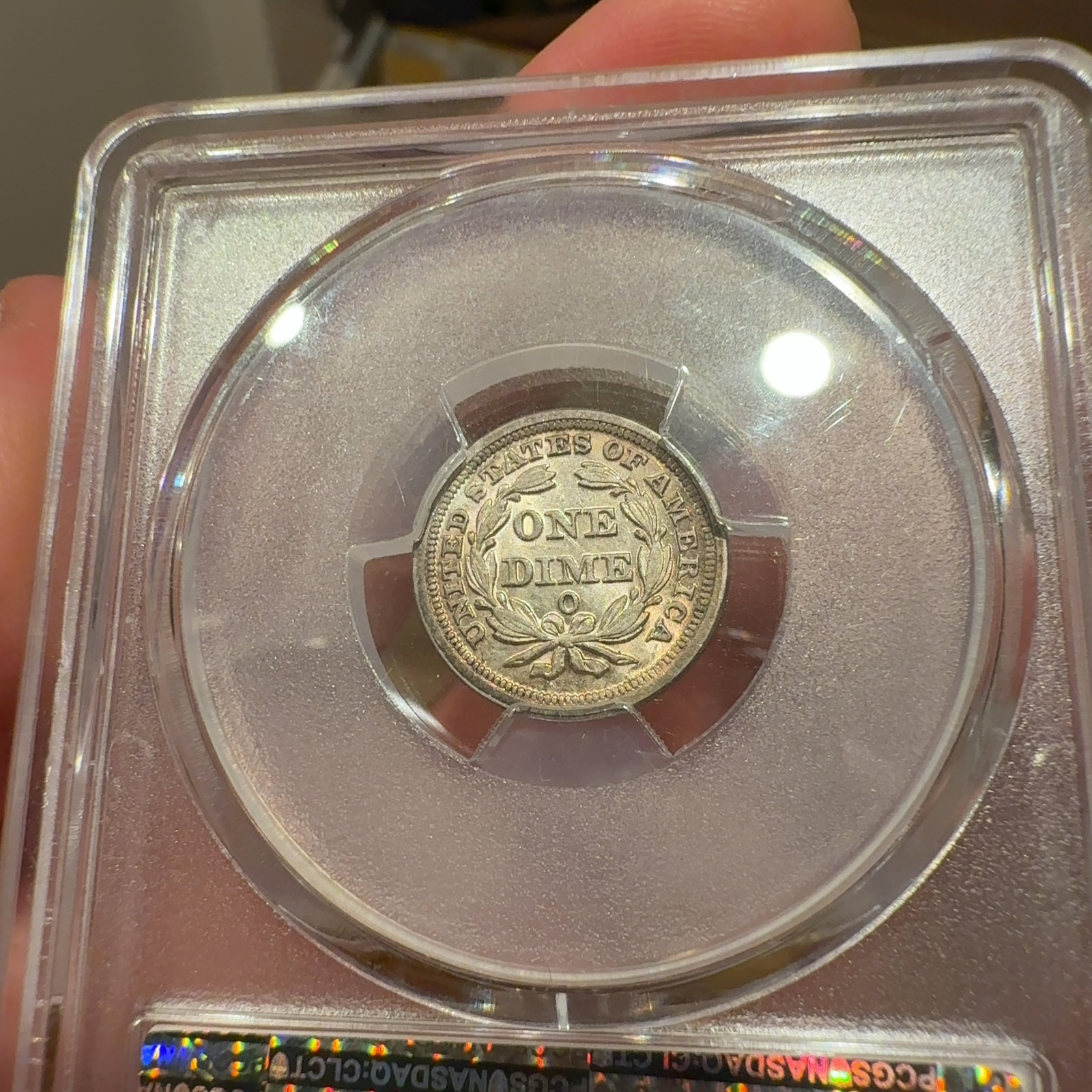 Handheld phone photograph 6 of the 1853-O Seated Liberty Dime in its holder