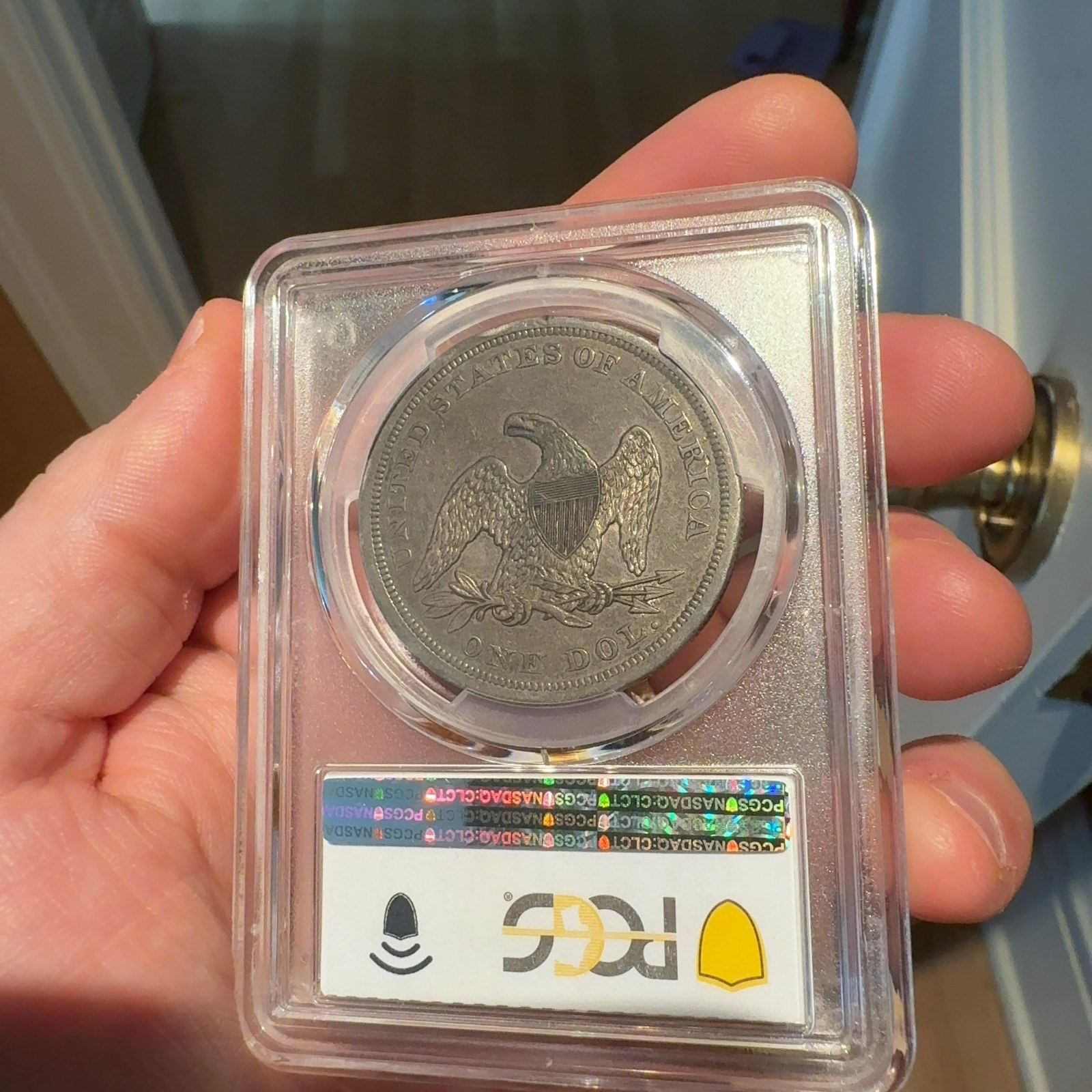 Handheld phone photograph 7 of the 1842 Silver Dollar in its holder