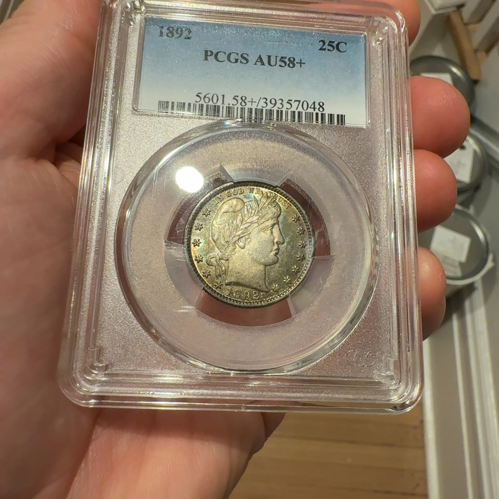 Handheld phone photograph 4 of the 1892 Barber Quarter in its holder