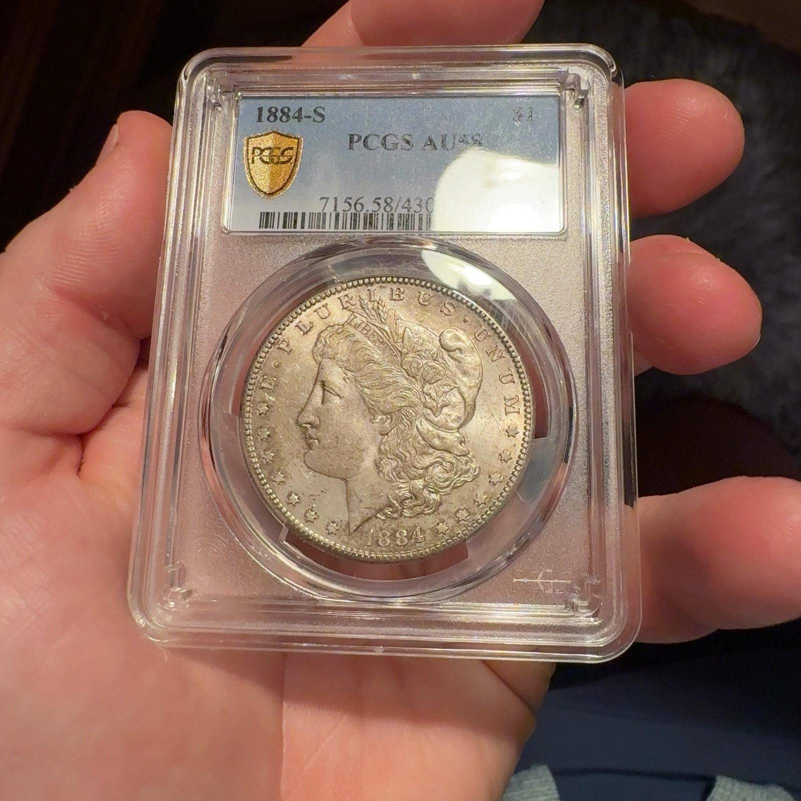 Handheld phone photograph 3 of the 1884-S Morgan Dollar in its holder