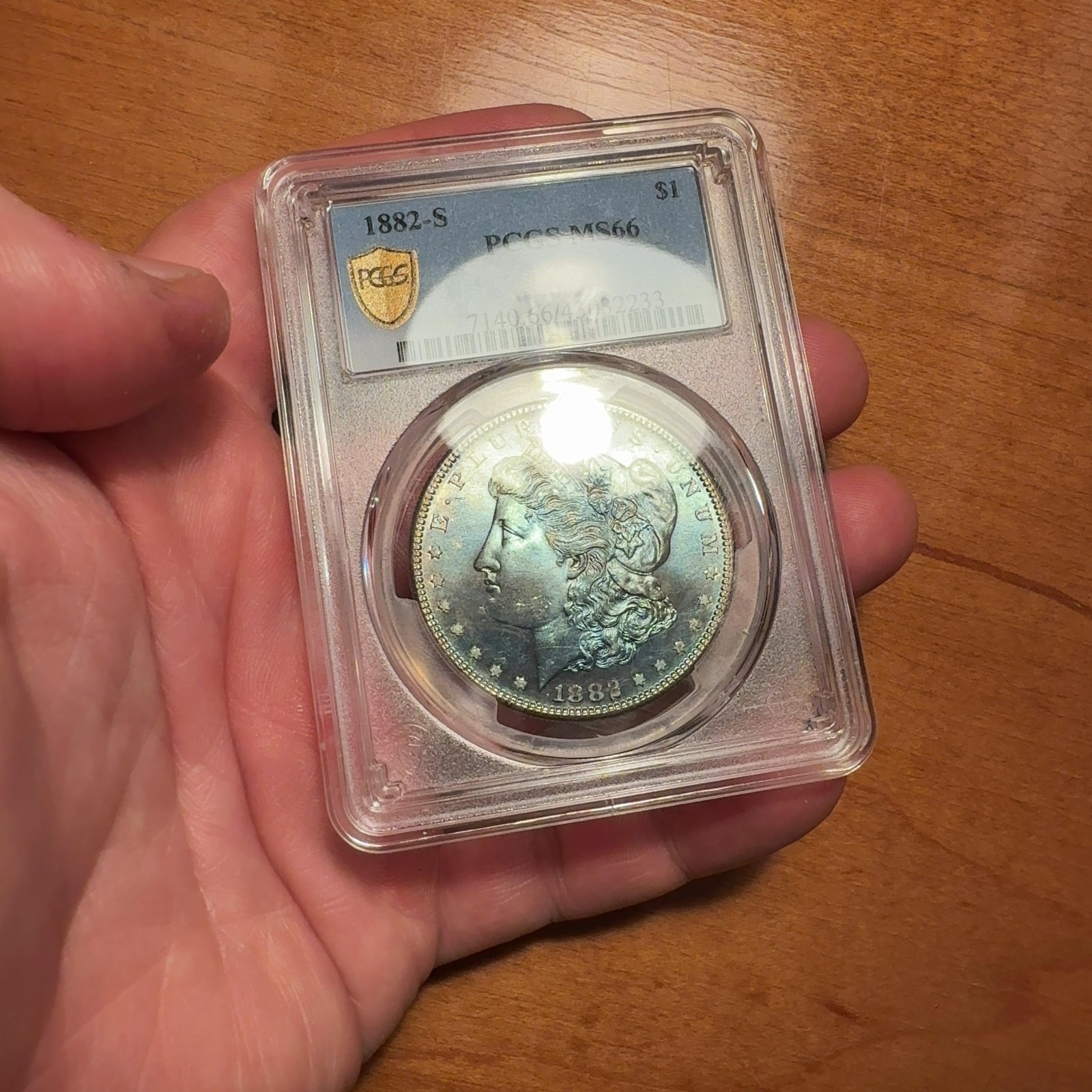 Handheld phone photograph 4 of the 1882-S Silver Dollar in its holder