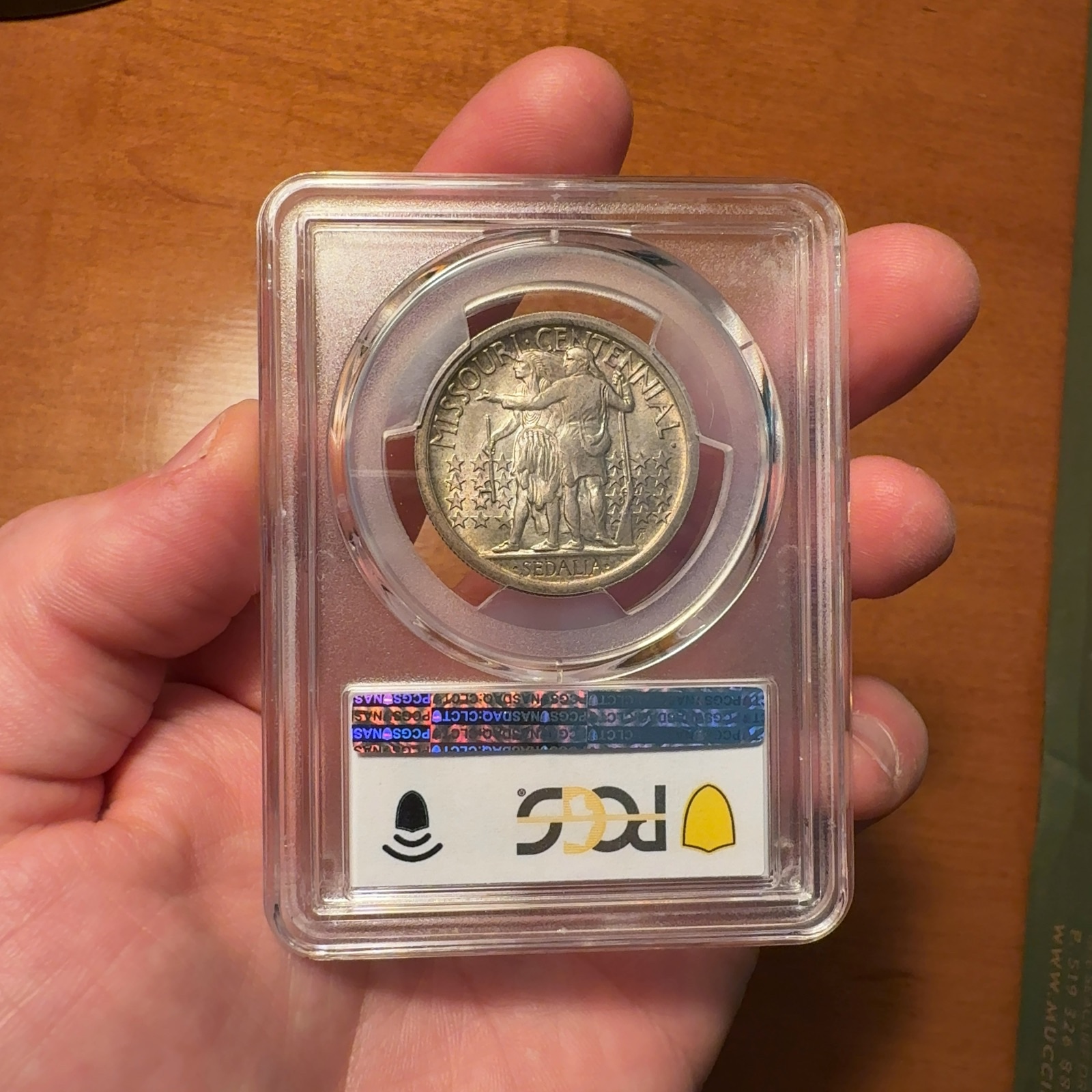 Handheld phone photograph 7 of the 1921 Missouri Half Dollar in its holder