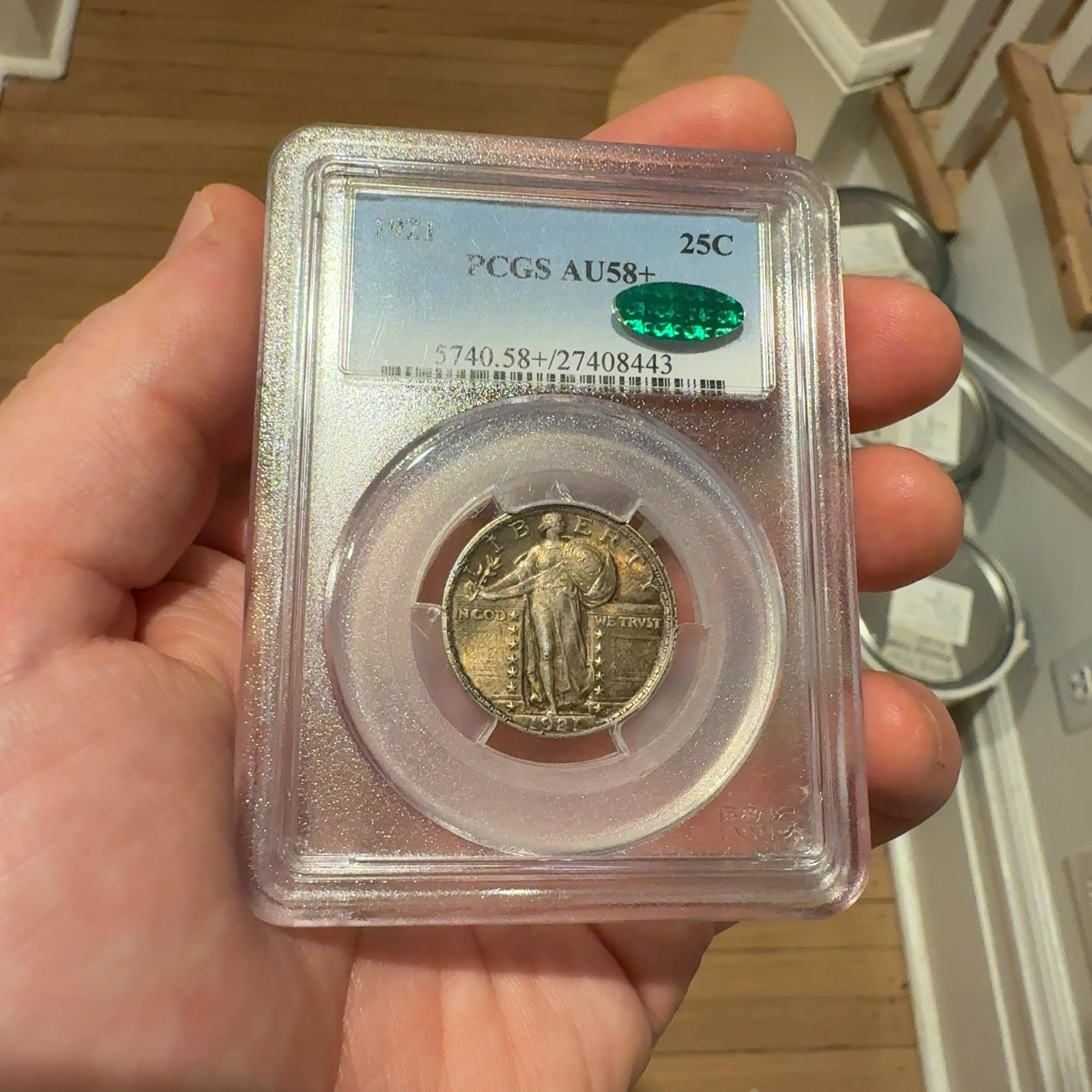 Handheld phone photograph 1 of the 1921 Standing Liberty Quarter in its holder