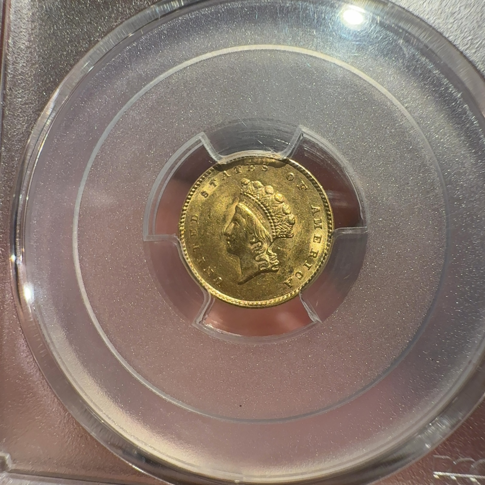 Handheld phone photograph 3 of the 1855 Gold Dollar in its holder