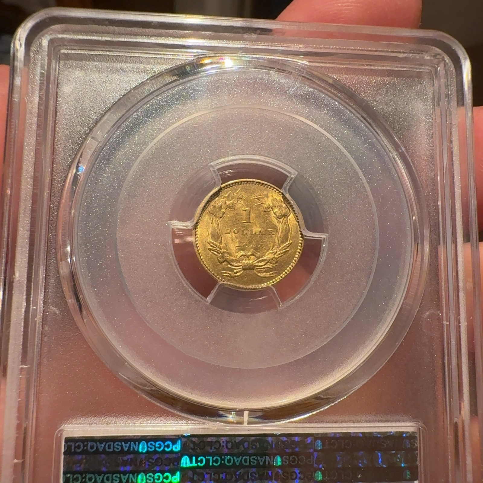 Handheld phone photograph 7 of the 1855 Gold Dollar in its holder