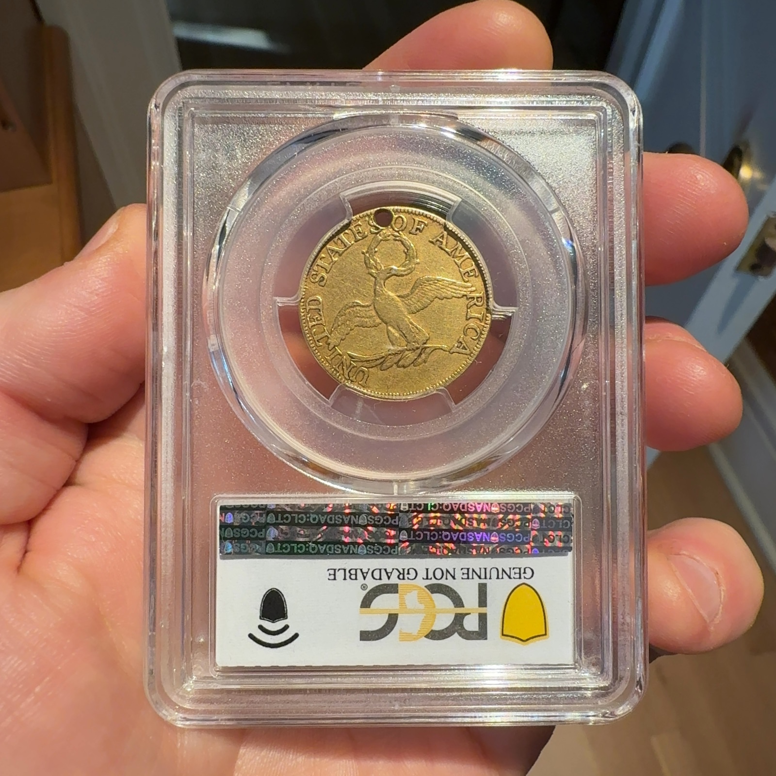 Handheld phone photograph 5 of the 1795 Half Eagle in its holder