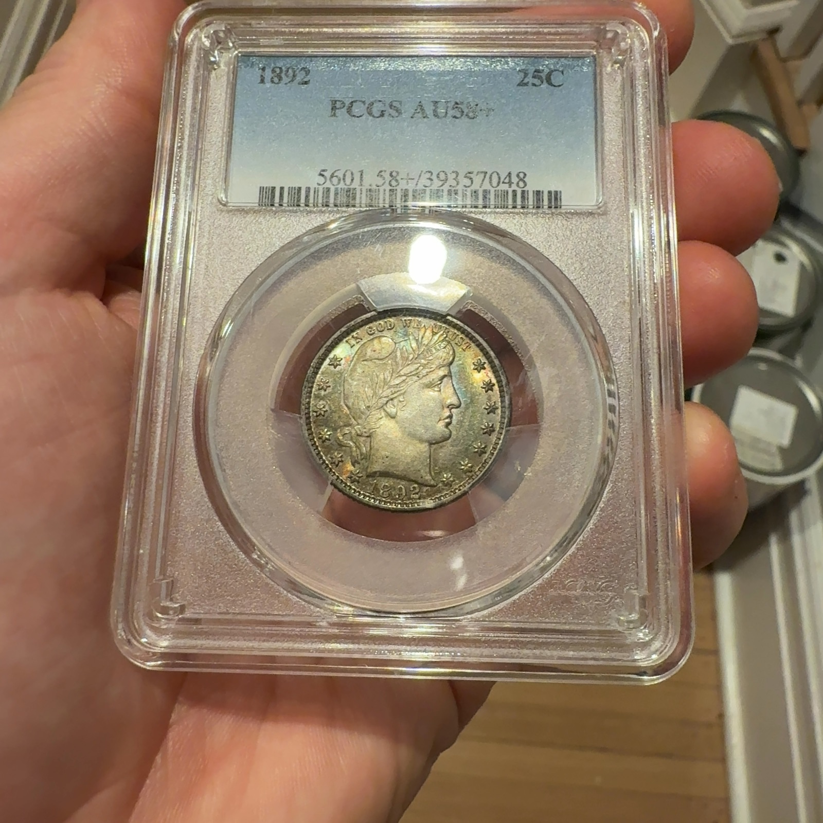 Handheld phone photograph 2 of the 1892 Barber Quarter in its holder