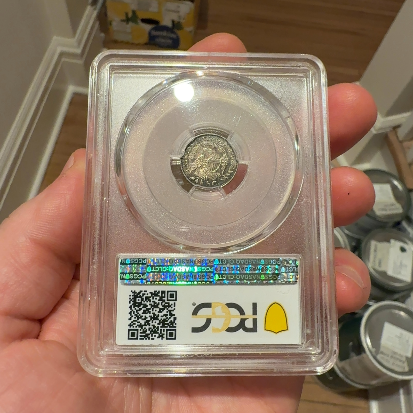 Handheld phone photograph 5 of the 1831 Capped Bust Half Dime in its holder
