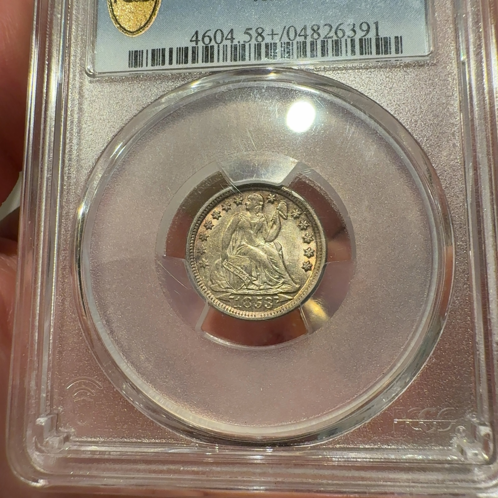 Handheld phone photograph 3 of the 1853-O Seated Liberty Dime in its holder