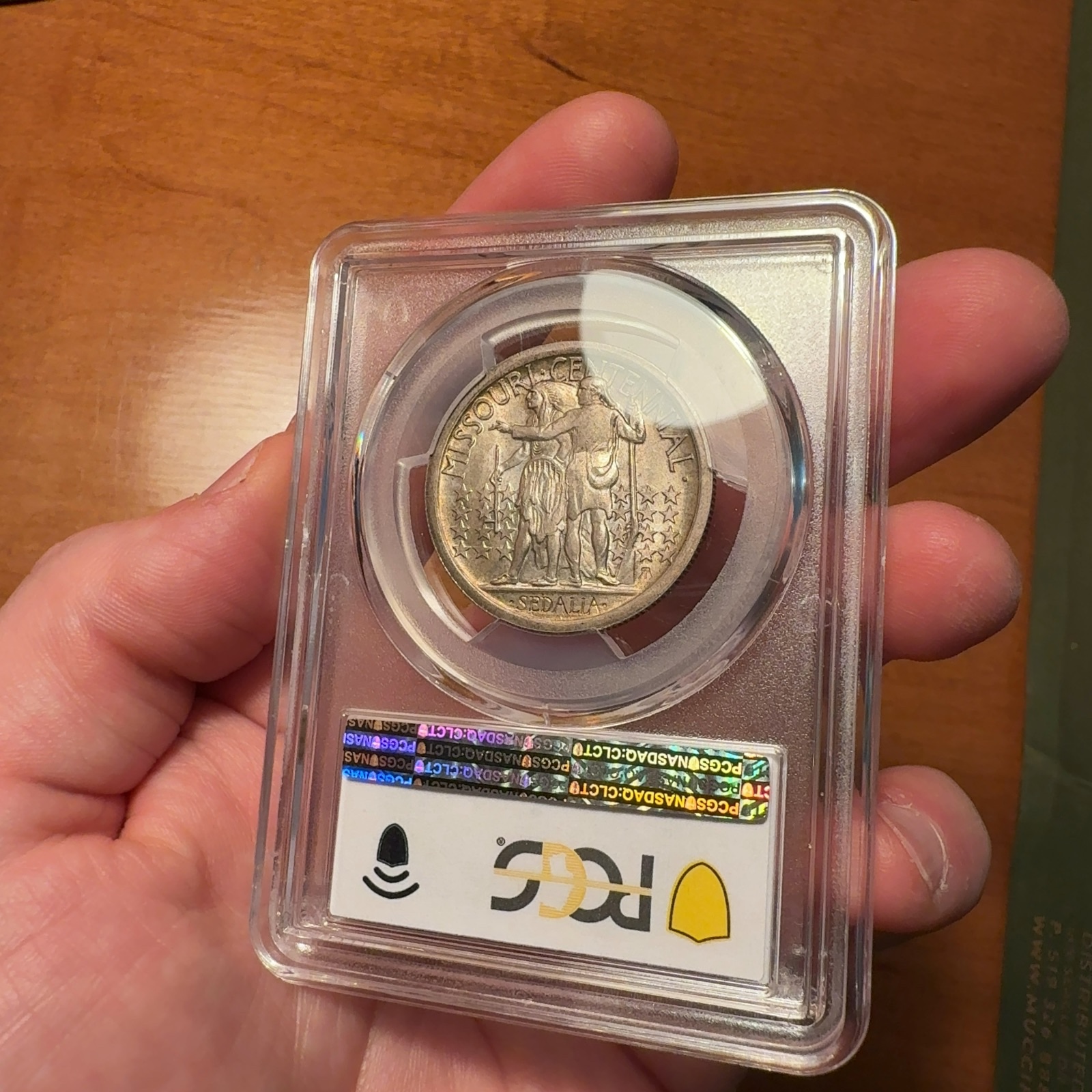 Handheld phone photograph 8 of the 1921 Missouri Half Dollar in its holder