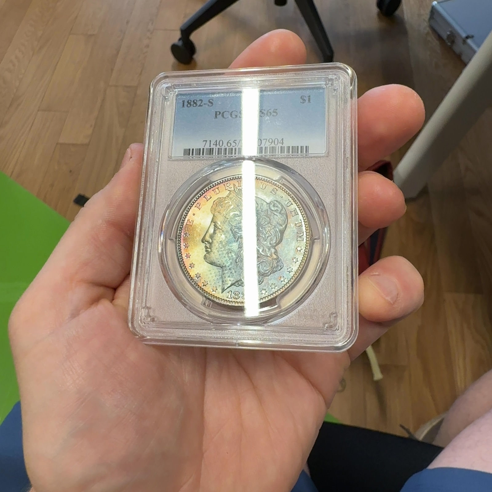 Handheld phone photograph 3 of the 1882-S Morgan Dollar in its holder