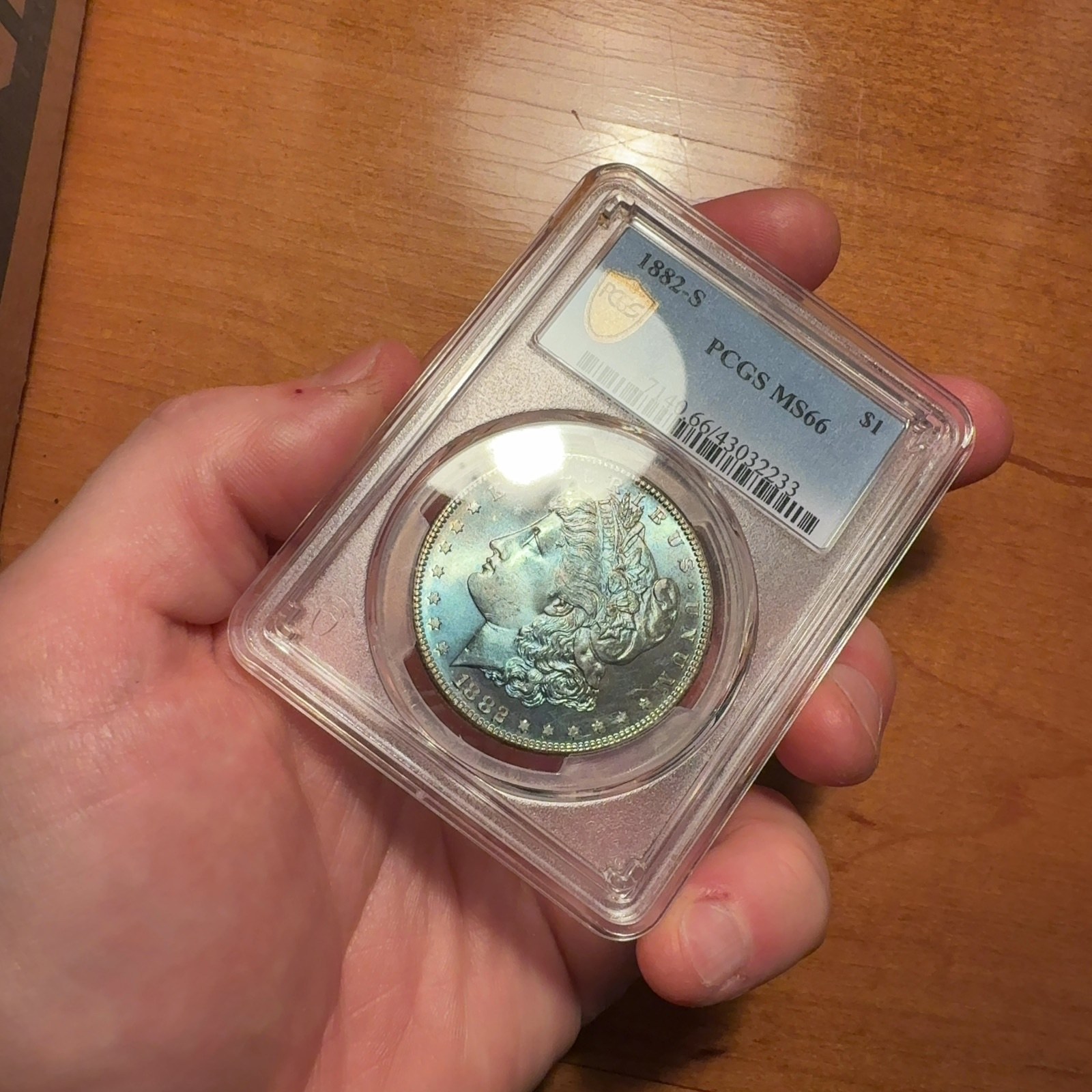 Handheld phone photograph 1 of the 1882-S Silver Dollar in its holder
