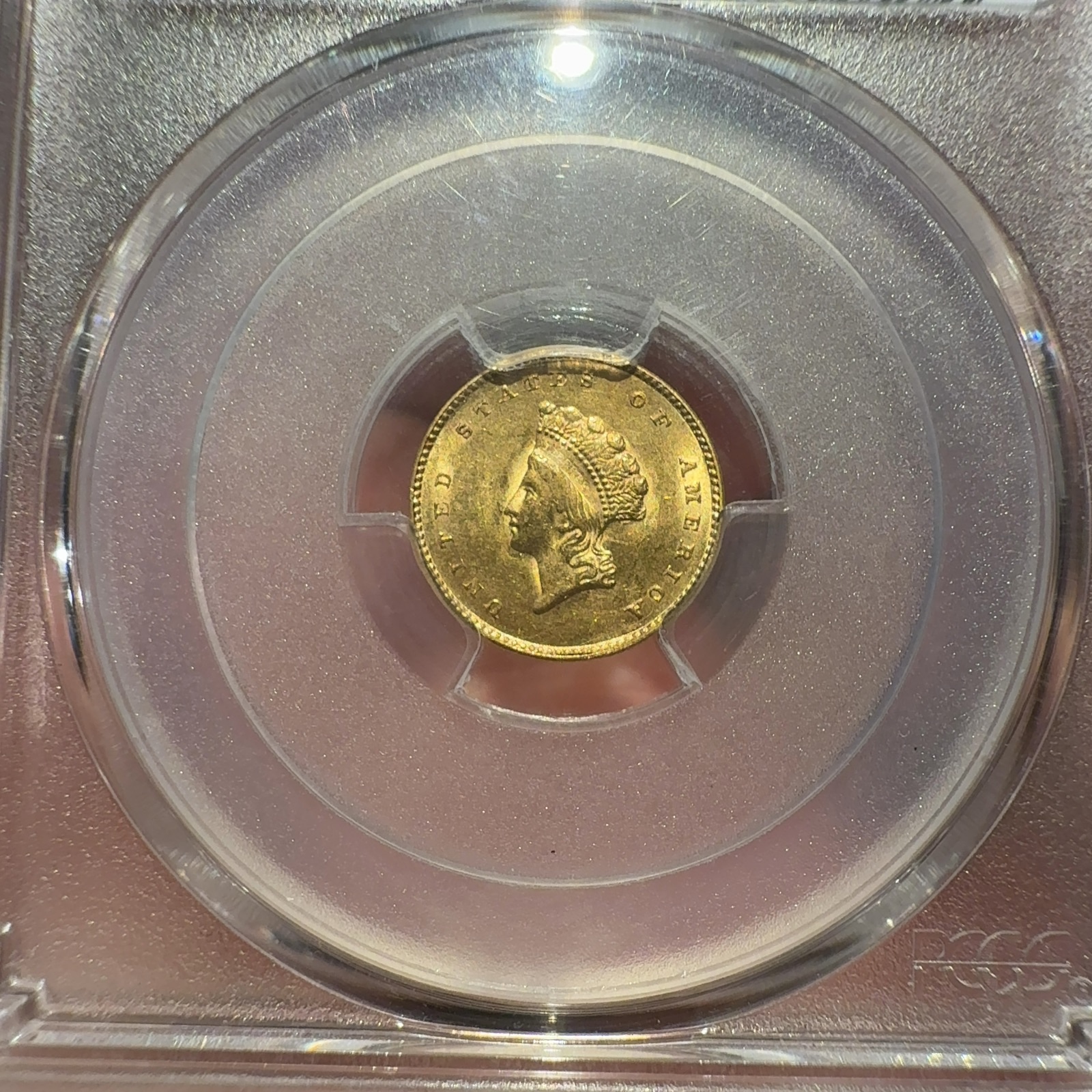 Handheld phone photograph 2 of the 1855 Gold Dollar in its holder