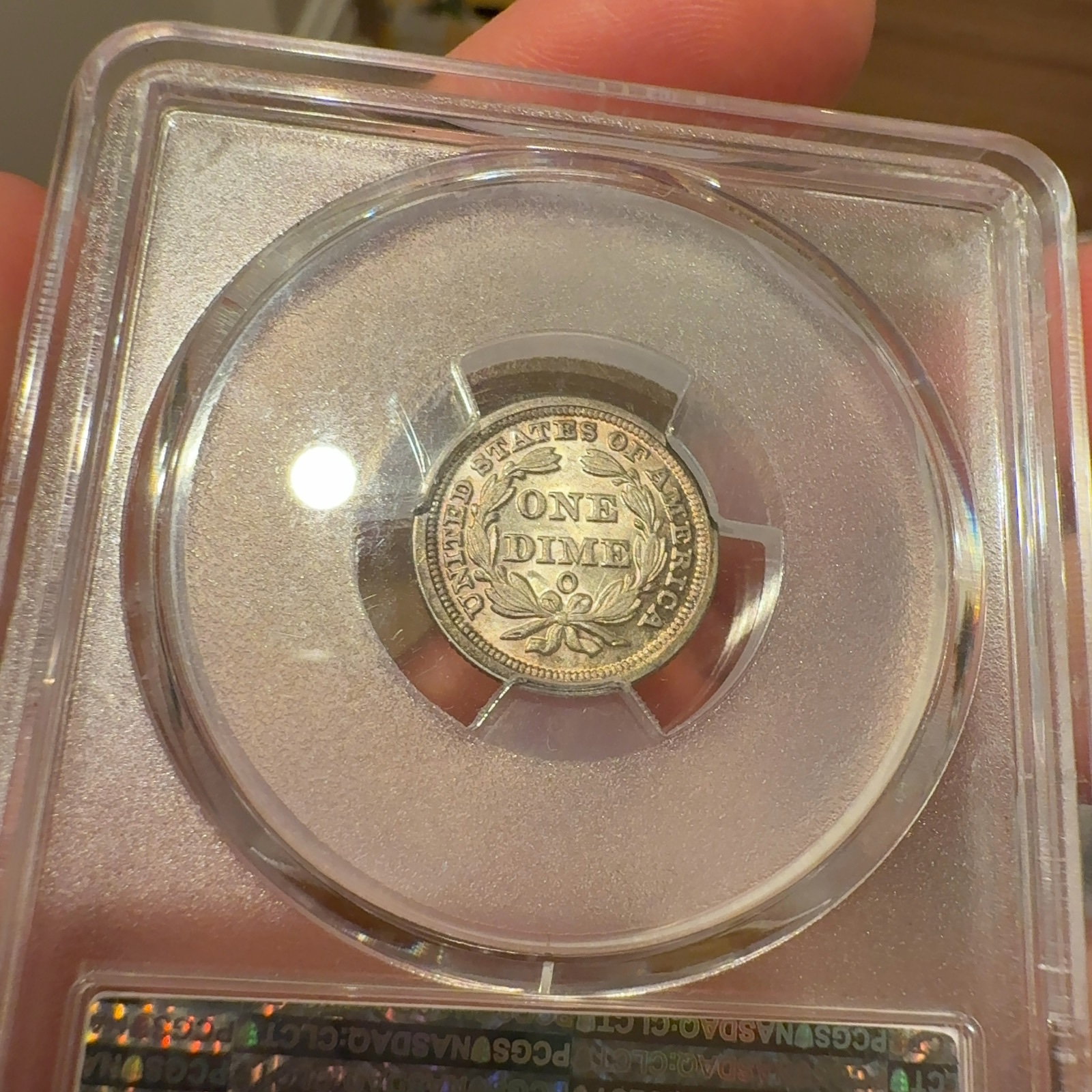Handheld phone photograph 8 of the 1853-O Seated Liberty Dime in its holder