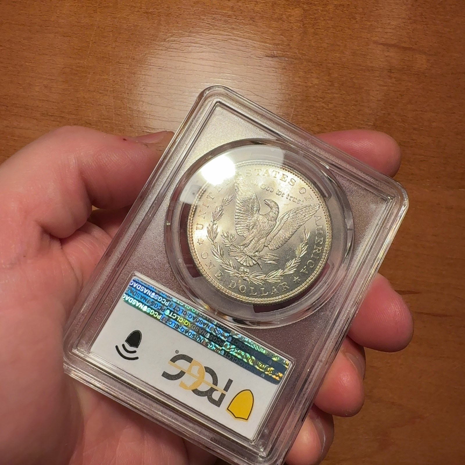 Handheld phone photograph 6 of the 1882-S Silver Dollar in its holder