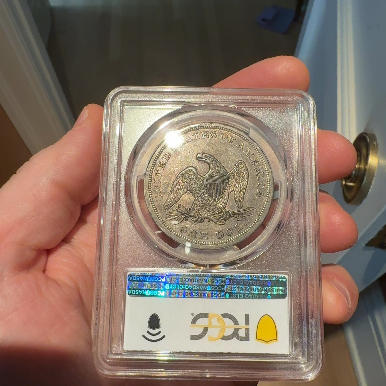 Handheld phone photograph 8 of the 1842 Silver Dollar in its holder