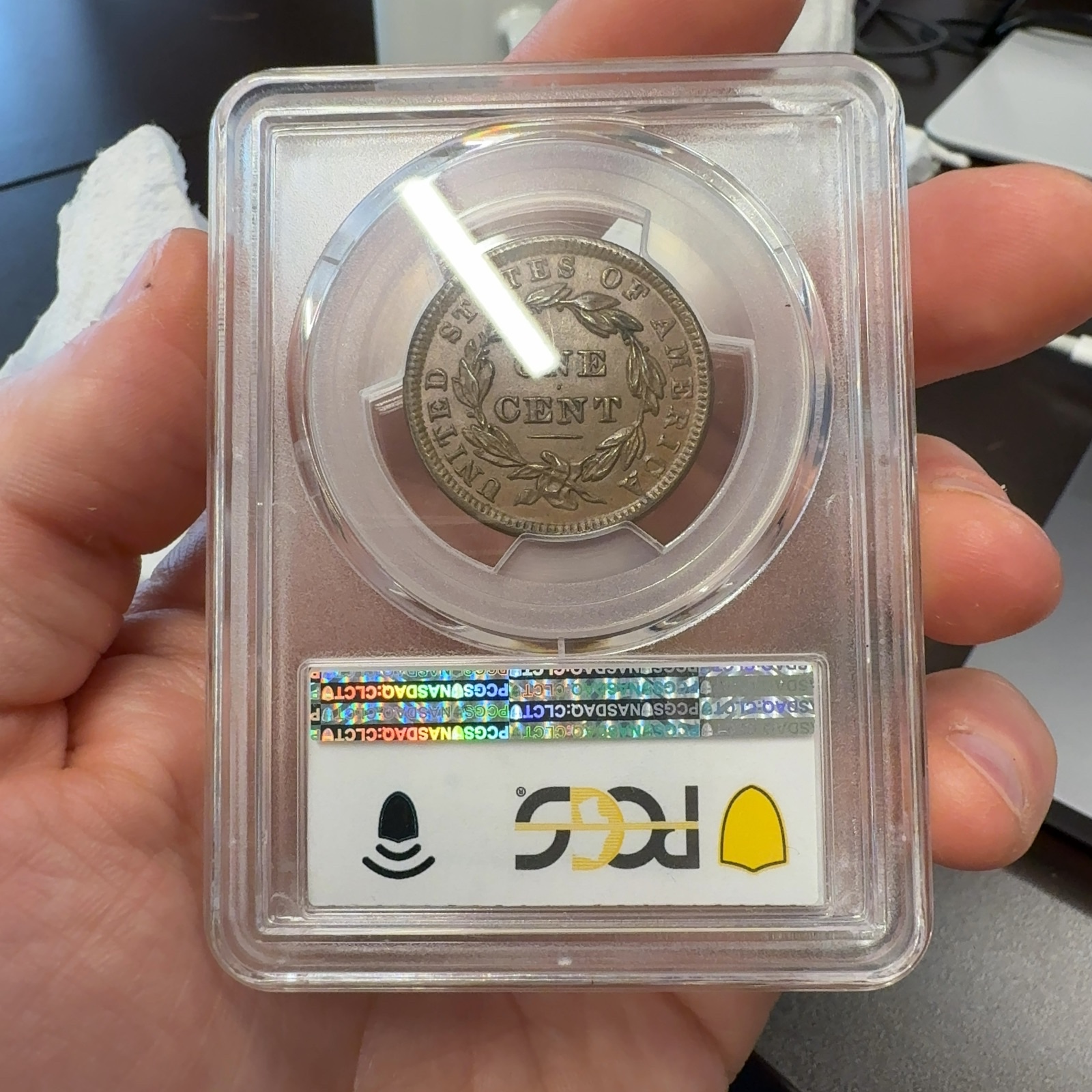 Handheld phone photograph 5 of the 1838 Coronet Large Cent in its holder