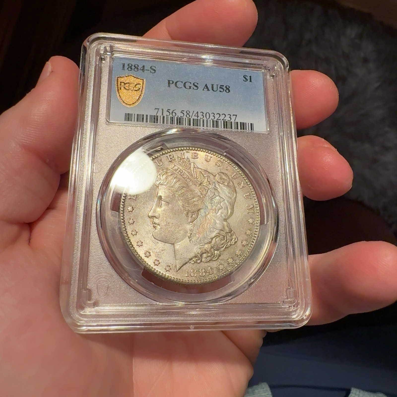 Handheld phone photograph 4 of the 1884-S Morgan Dollar in its holder