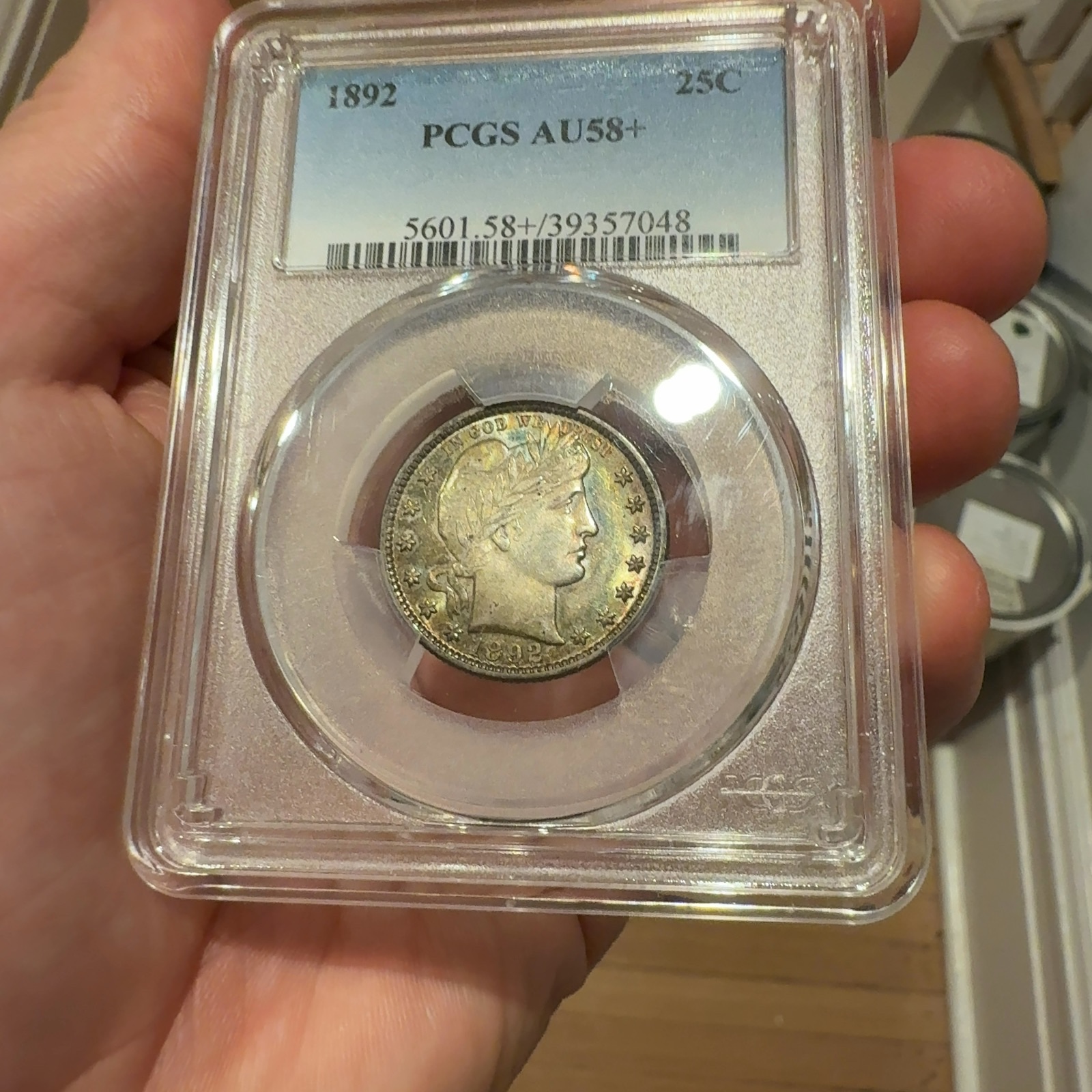 Handheld phone photograph 3 of the 1892 Barber Quarter in its holder