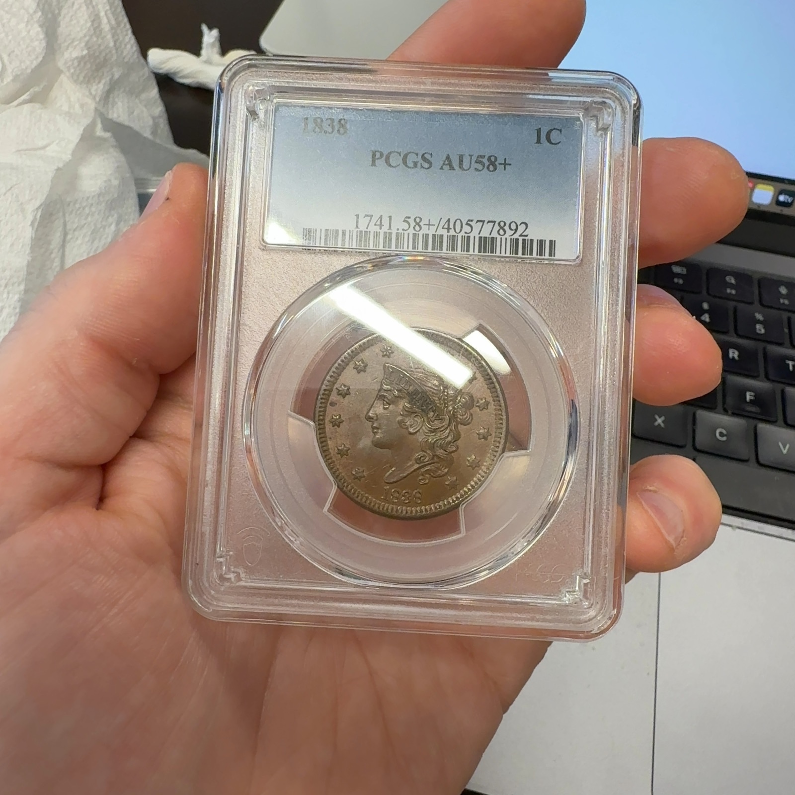 Handheld phone photograph 1 of the 1838 Coronet Large Cent in its holder