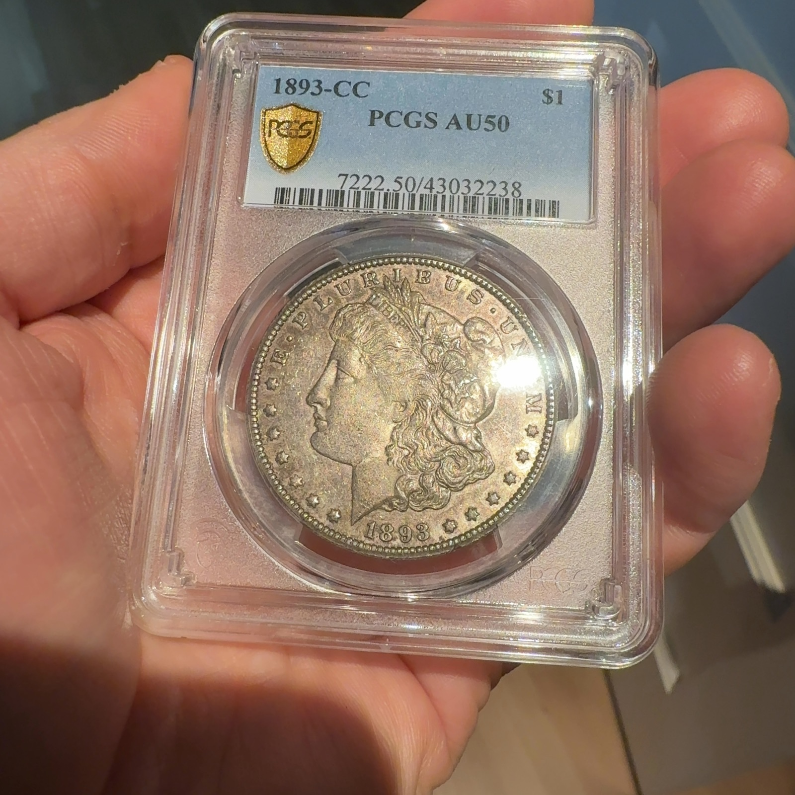 Handheld phone photograph 3 of the 1893-CC Morgan Dollar in its holder