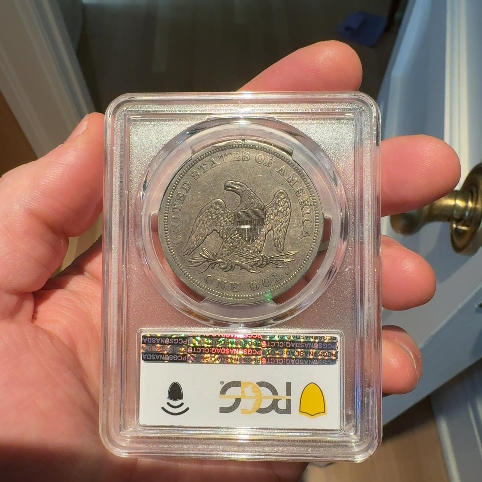 Handheld phone photograph 5 of the 1842 Silver Dollar in its holder
