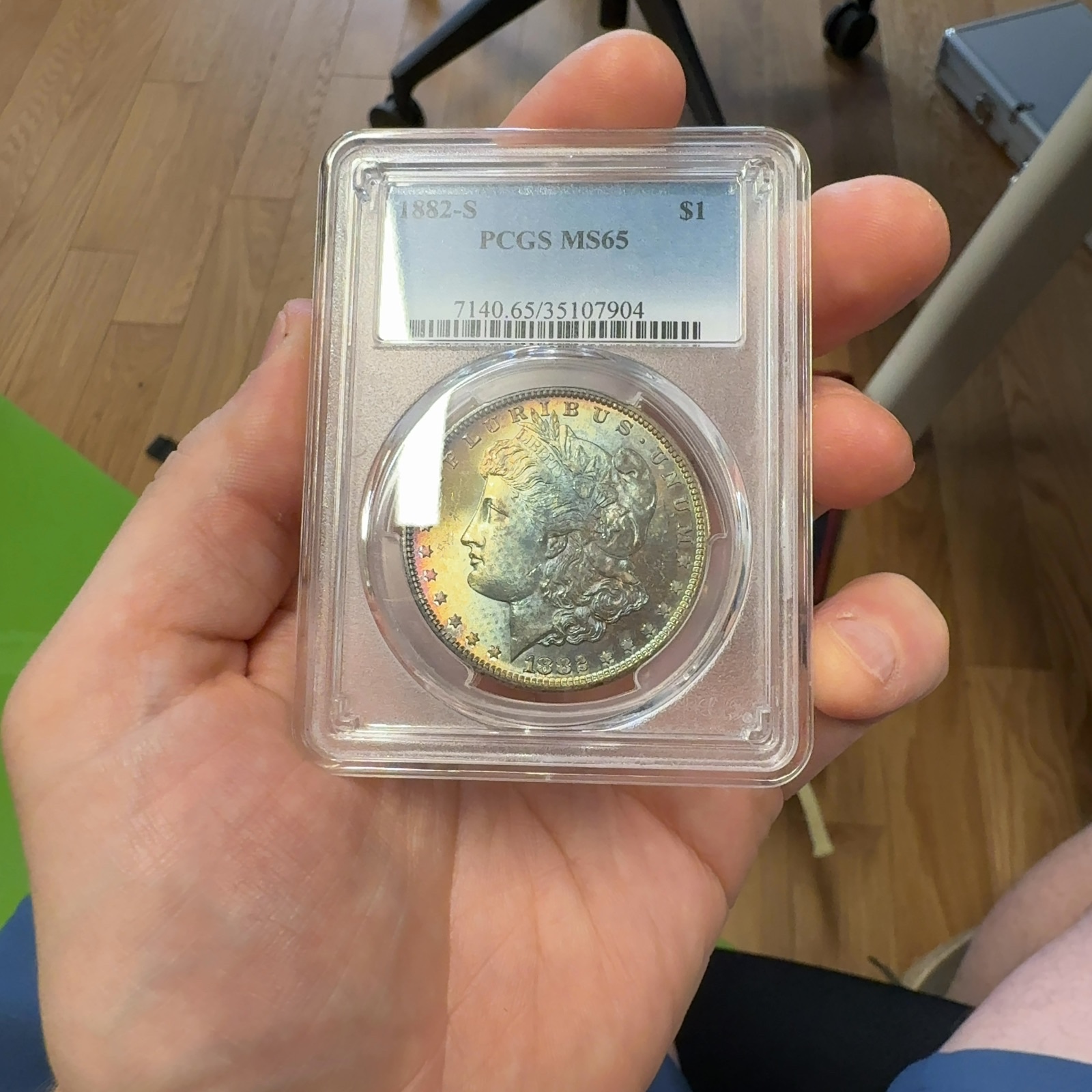 Handheld phone photograph 1 of the 1882-S Morgan Dollar in its holder