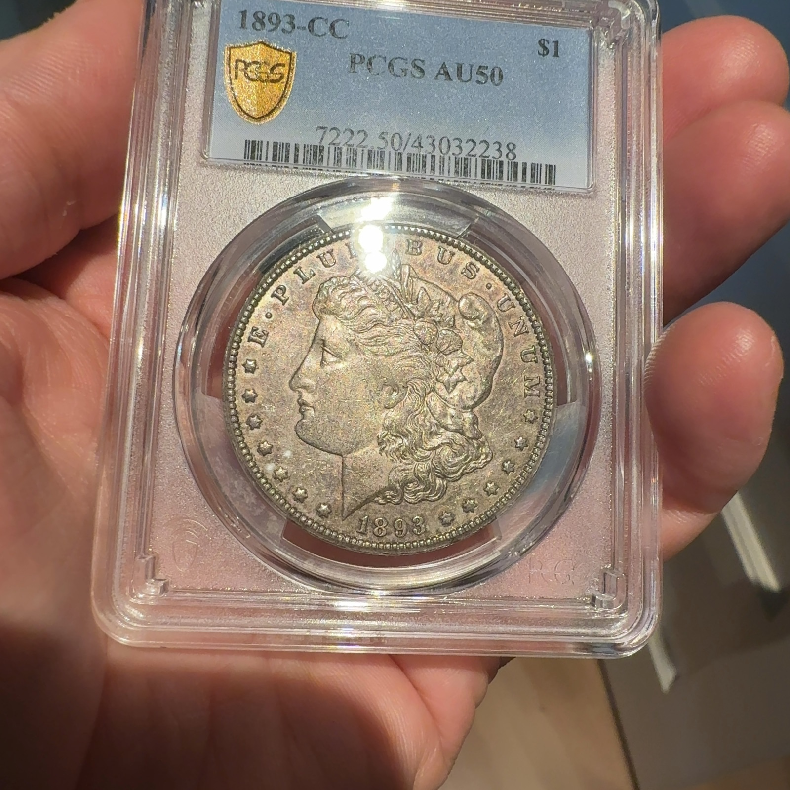 Handheld phone photograph 4 of the 1893-CC Morgan Dollar in its holder