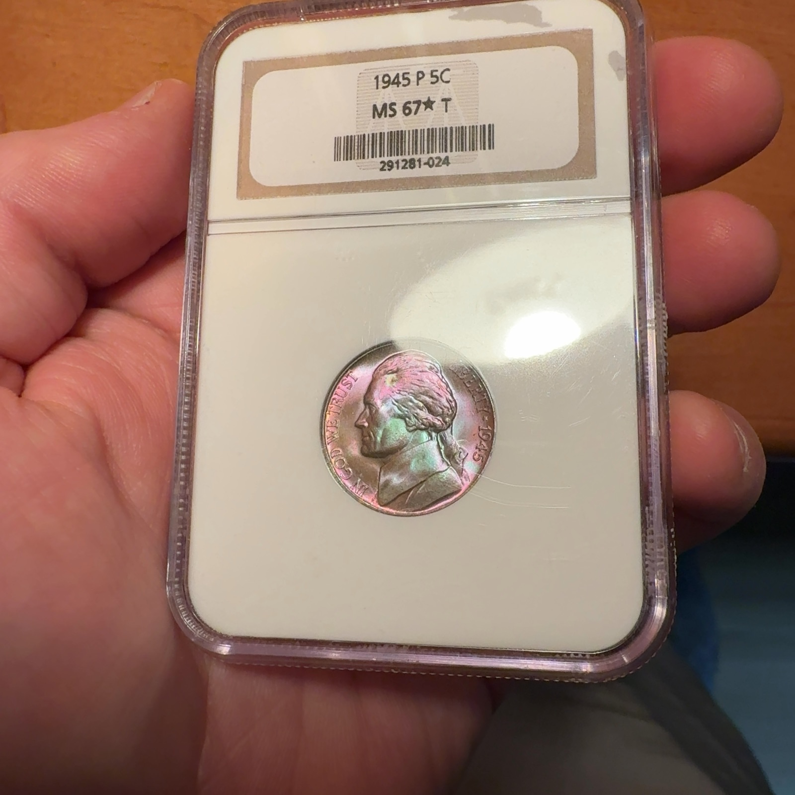 Handheld phone photograph 2 of the 1945-P Jefferson Nickel in its holder