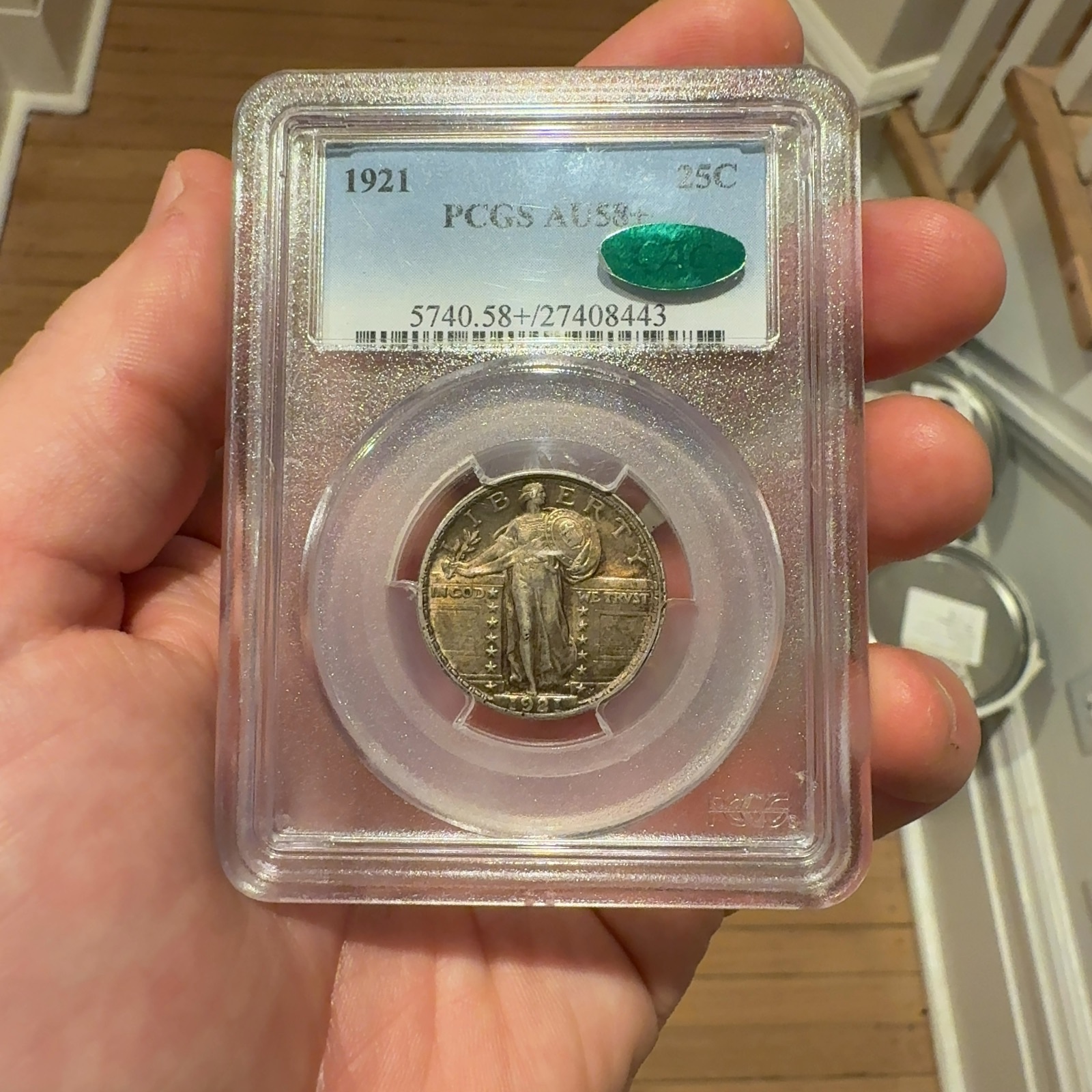 Handheld phone photograph 2 of the 1921 Standing Liberty Quarter in its holder