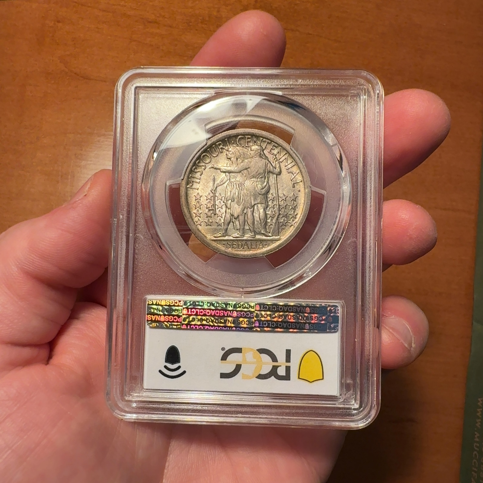 Handheld phone photograph 5 of the 1921 Missouri Half Dollar in its holder