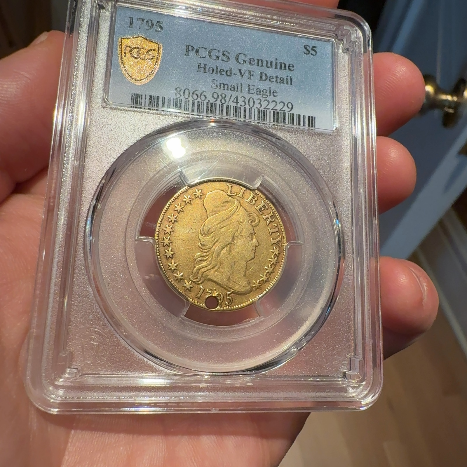 Handheld phone photograph 2 of the 1795 Half Eagle in its holder