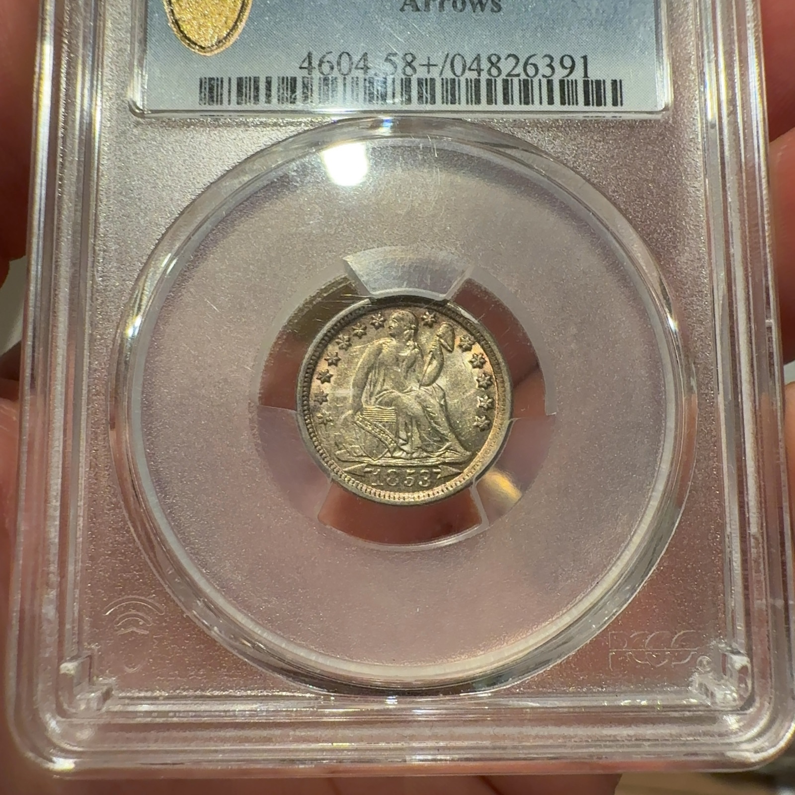 Handheld phone photograph 2 of the 1853-O Seated Liberty Dime in its holder