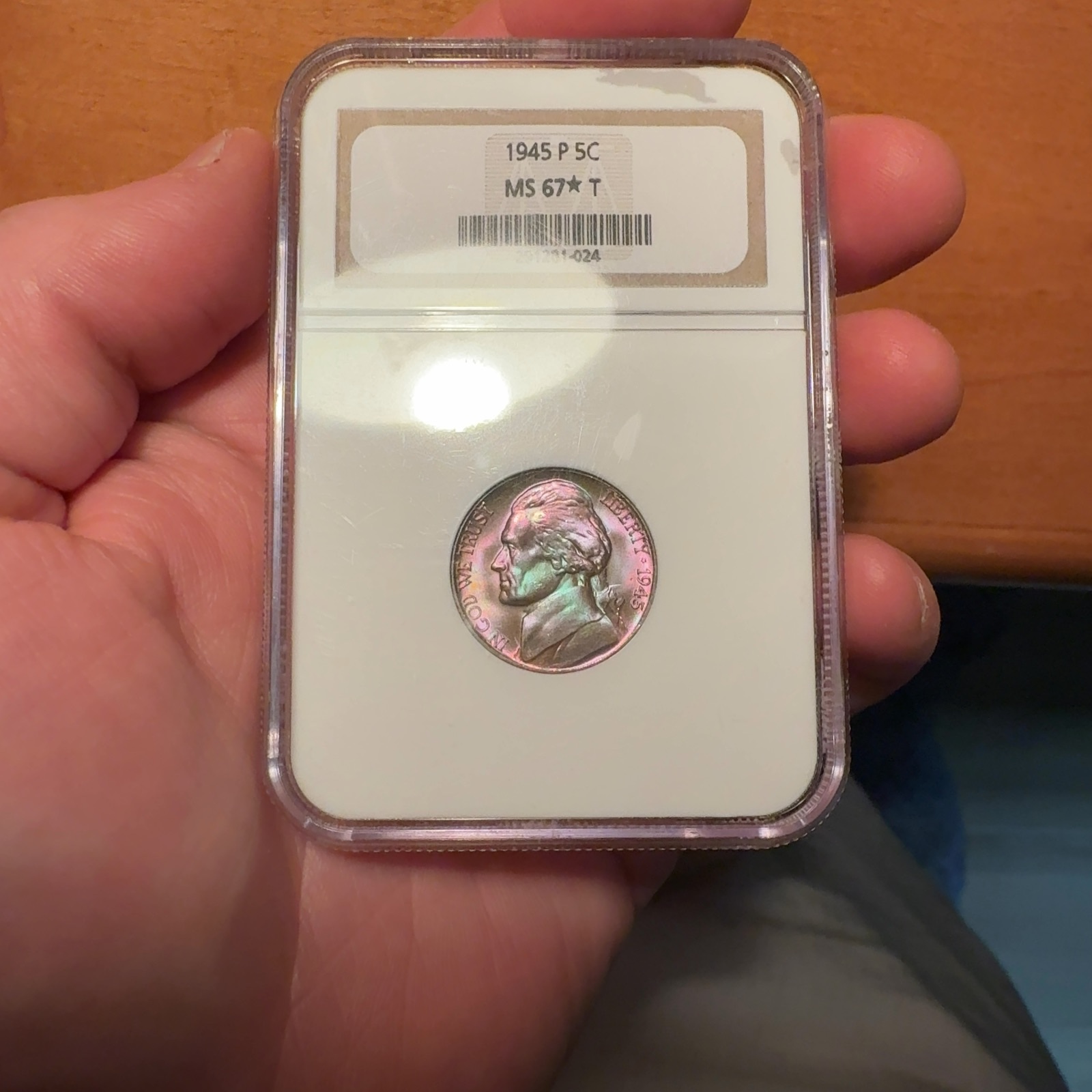 Handheld phone photograph 1 of the 1945-P Jefferson Nickel in its holder