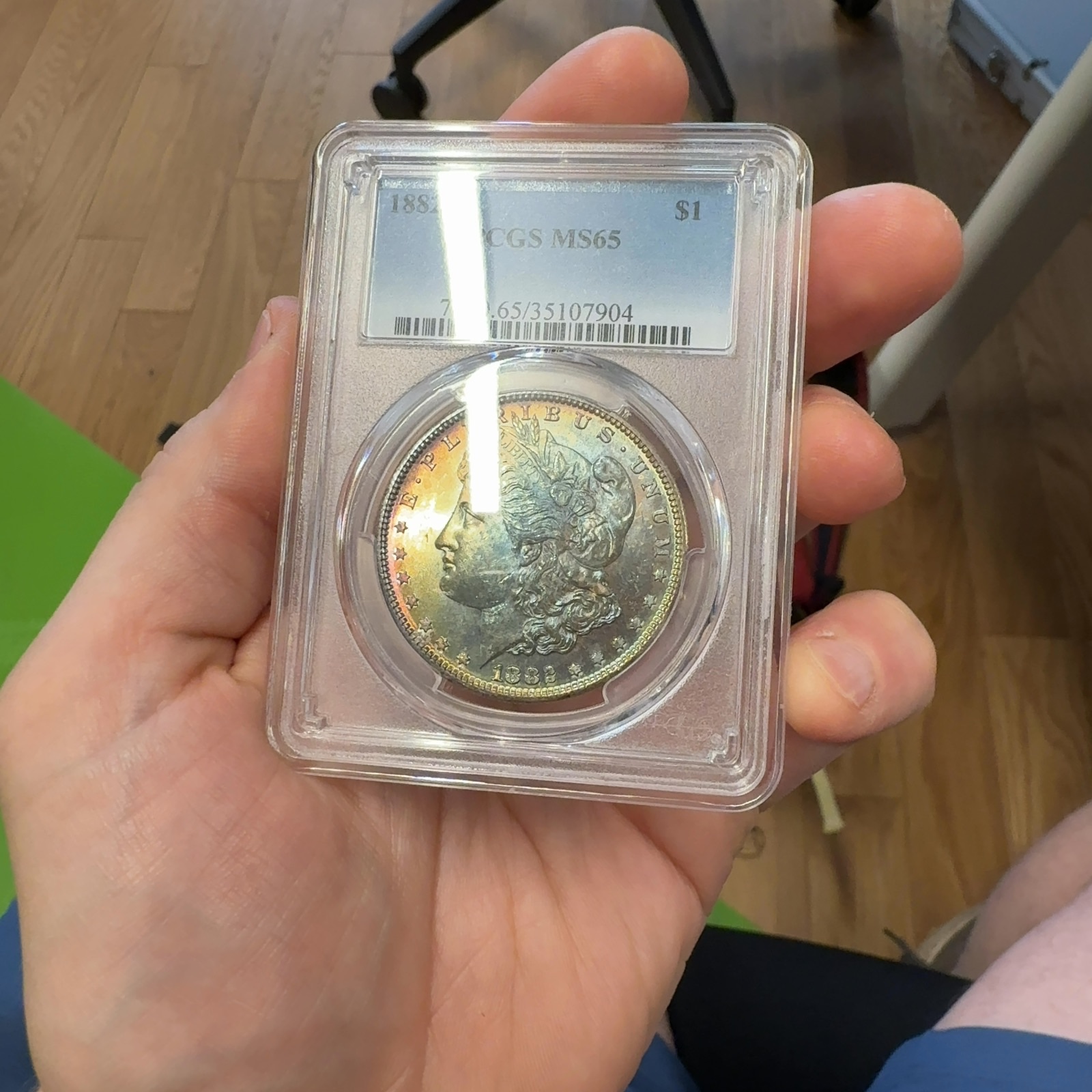 Handheld phone photograph 4 of the 1882-S Morgan Dollar in its holder