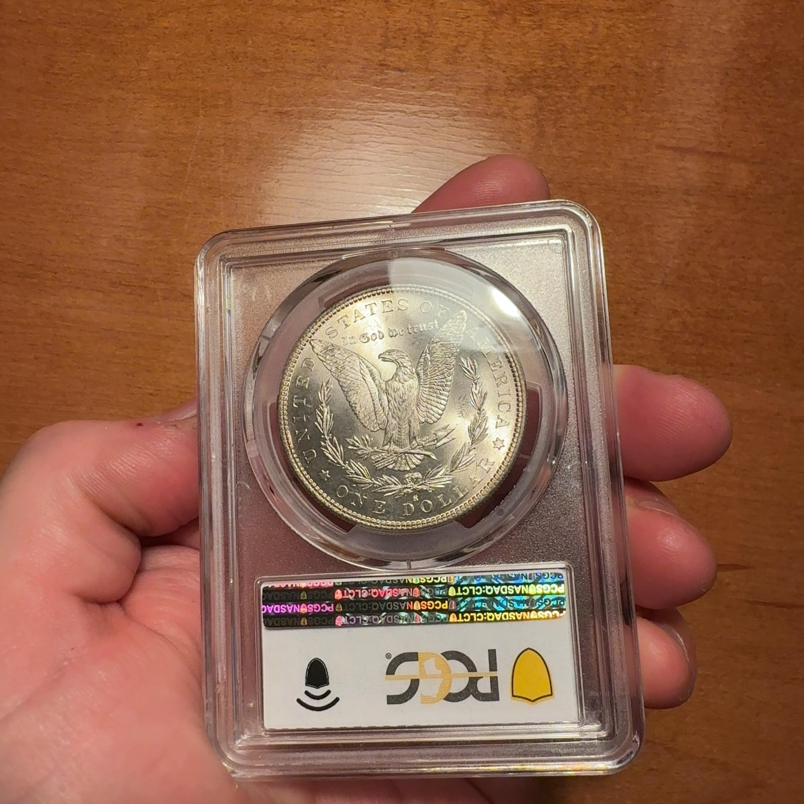 Handheld phone photograph 7 of the 1882-S Silver Dollar in its holder