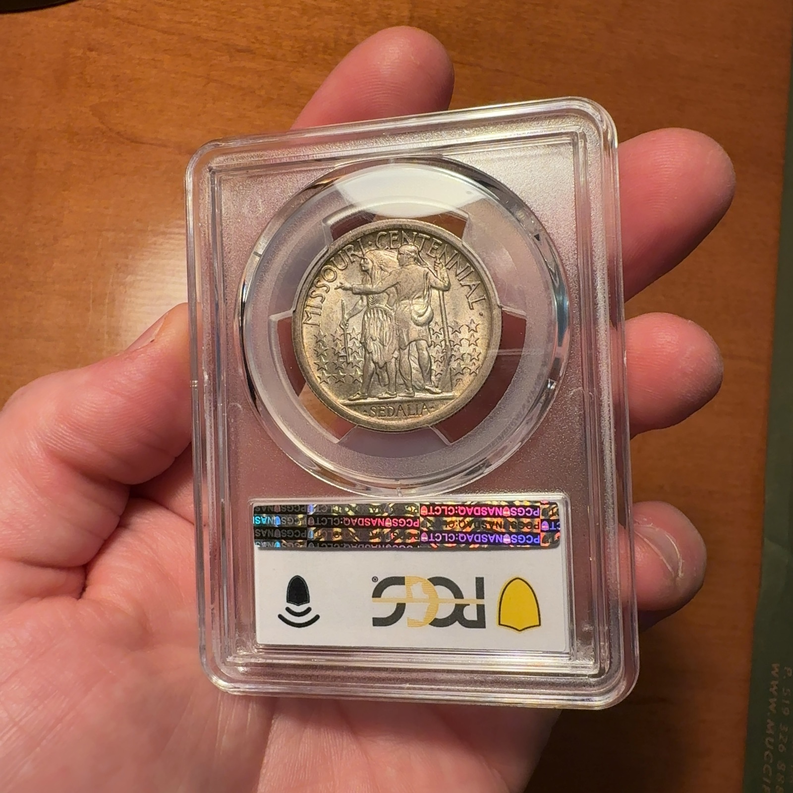 Handheld phone photograph 6 of the 1921 Missouri Half Dollar in its holder