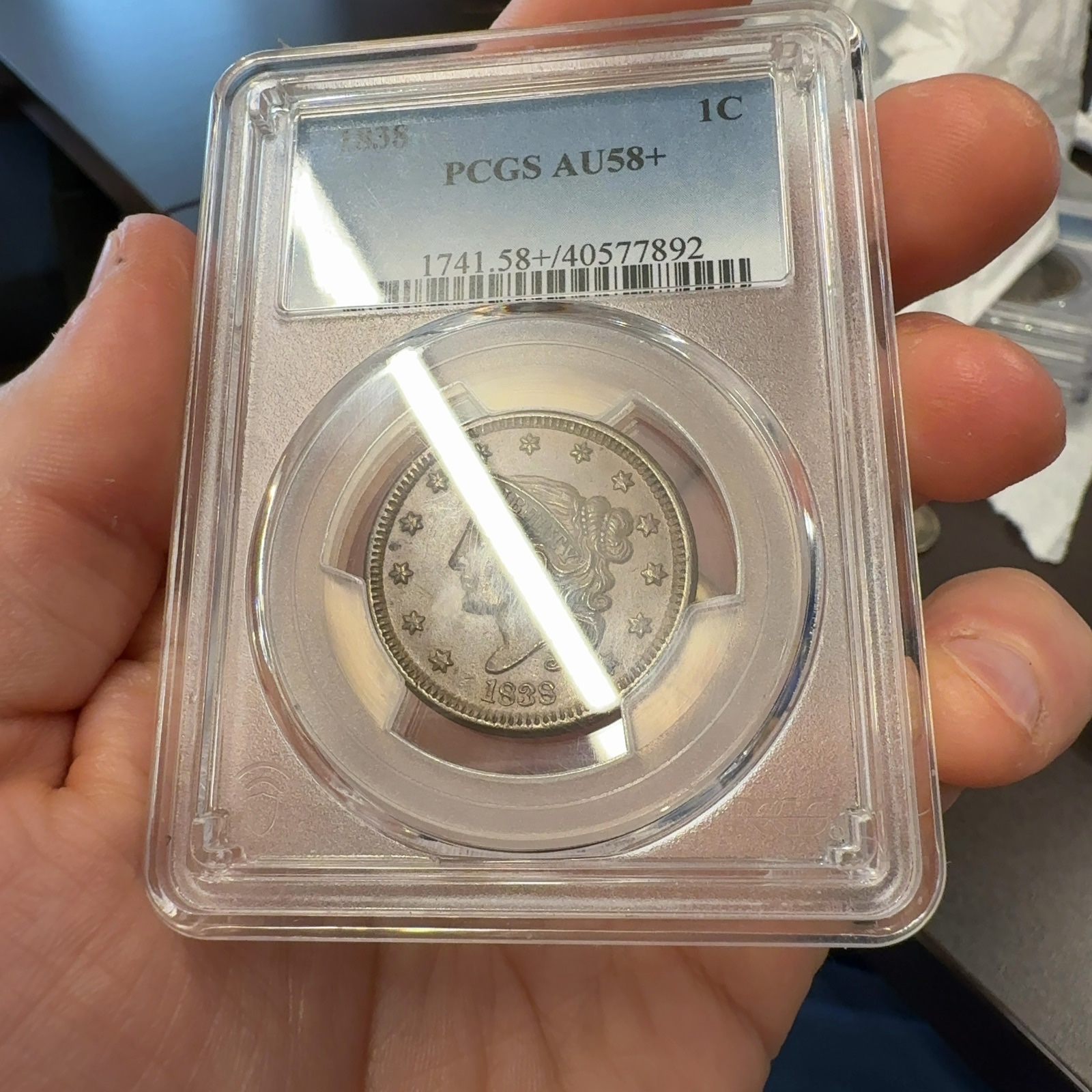 Handheld phone photograph 3 of the 1838 Coronet Large Cent in its holder