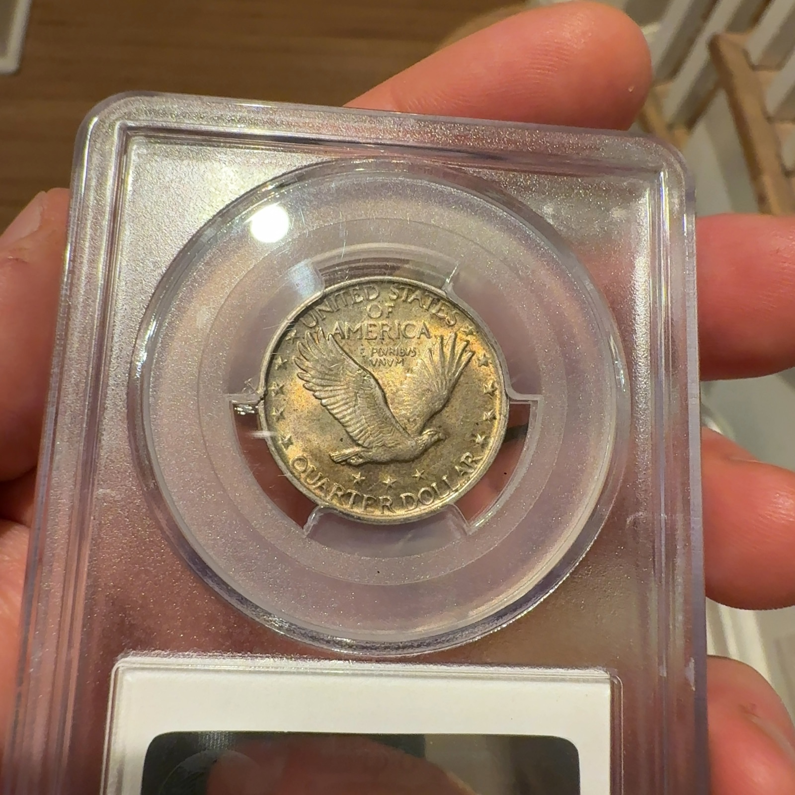 Handheld phone photograph 7 of the 1921 Standing Liberty Quarter in its holder