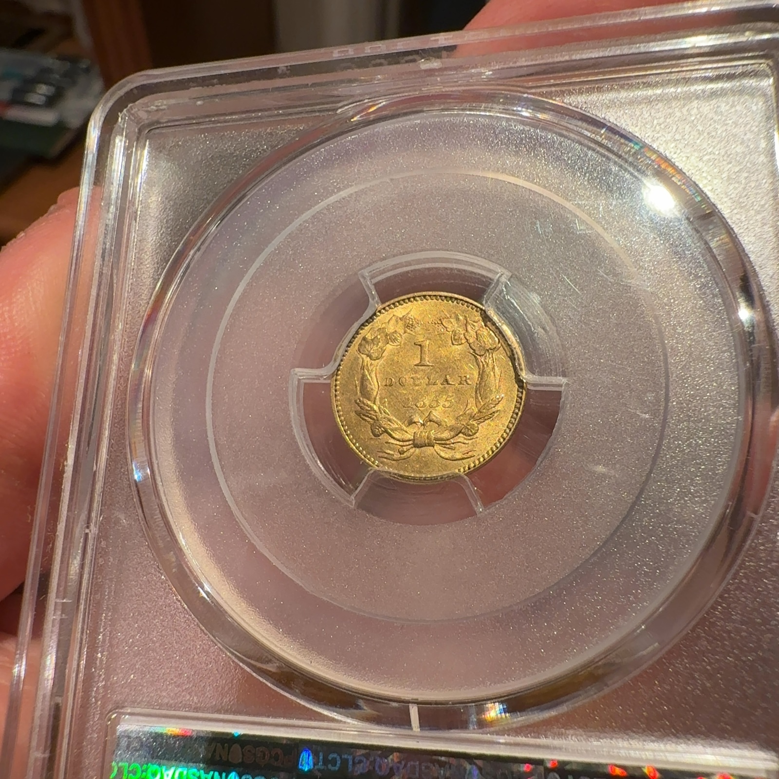 Handheld phone photograph 8 of the 1855 Gold Dollar in its holder